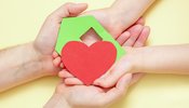 hands_holds_green_paper_house_with_red_heart