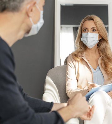 man_with_mask_talking_to_woman_counselor