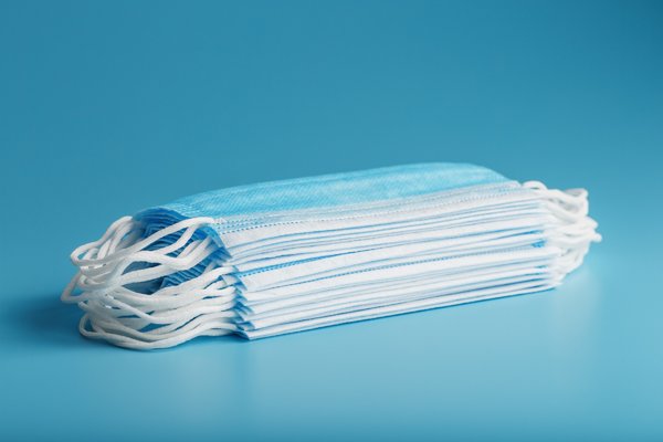 stack_of_protective_medical_masks_on_a_blue_table_isolate_protection_against_diseases_viruses_and...