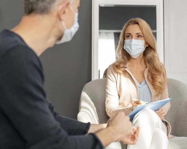 man_with_mask_talking_to_woman_counselor